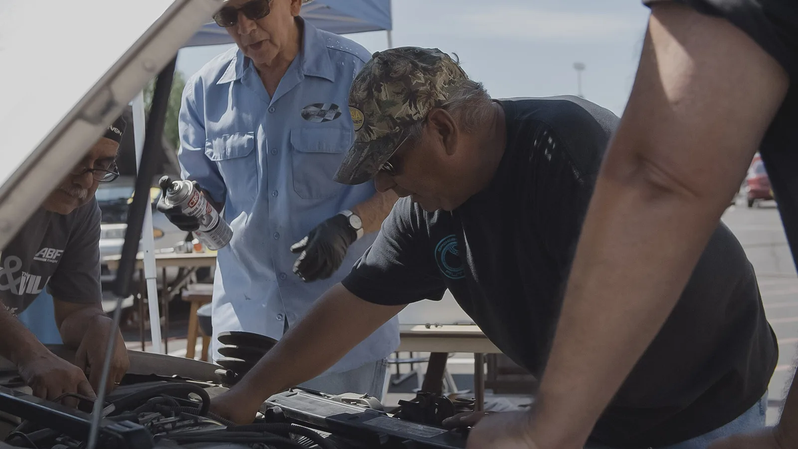 Volunteers helping repair a car during a Sagebrush serve event.