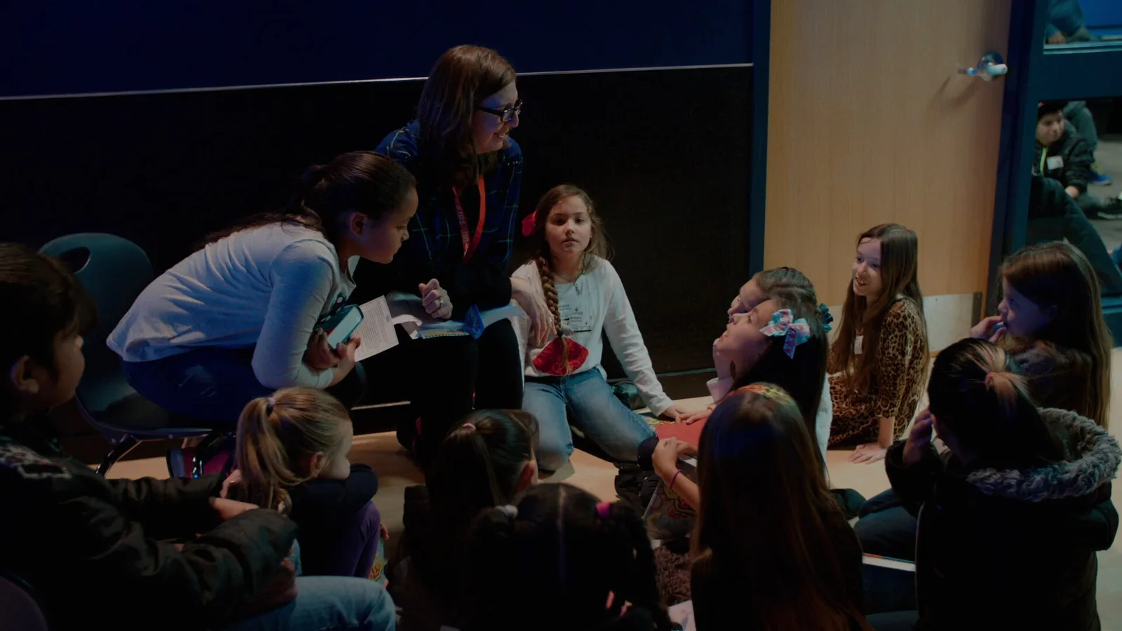 A Sagebrush volunteer sitting with kids during a small group moment.